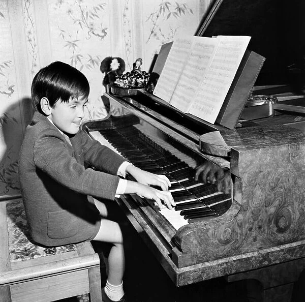 Seven year old boy playing songs on the piano which he has written himself